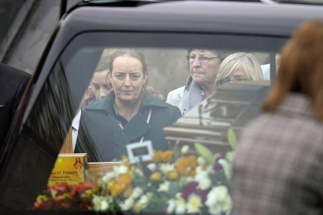 Tracey O’Flaherty, the widow of James O’Flaherty, watches as his coffin arrives for his funeral mass at St Mary’s Church, Derrybeg (Niall Carson/PA)