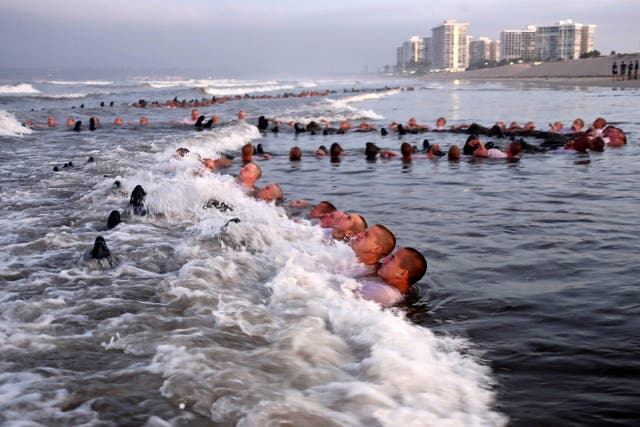 <p>FILE - U.S. Navy SEAL candidates, participate in “surf immersion” during Basic Underwater Demolition/SEAL (BUD/S) training at the Naval Special Warfare (NSW) Center in Coronado, Calif., on May 4, 2020. </p>