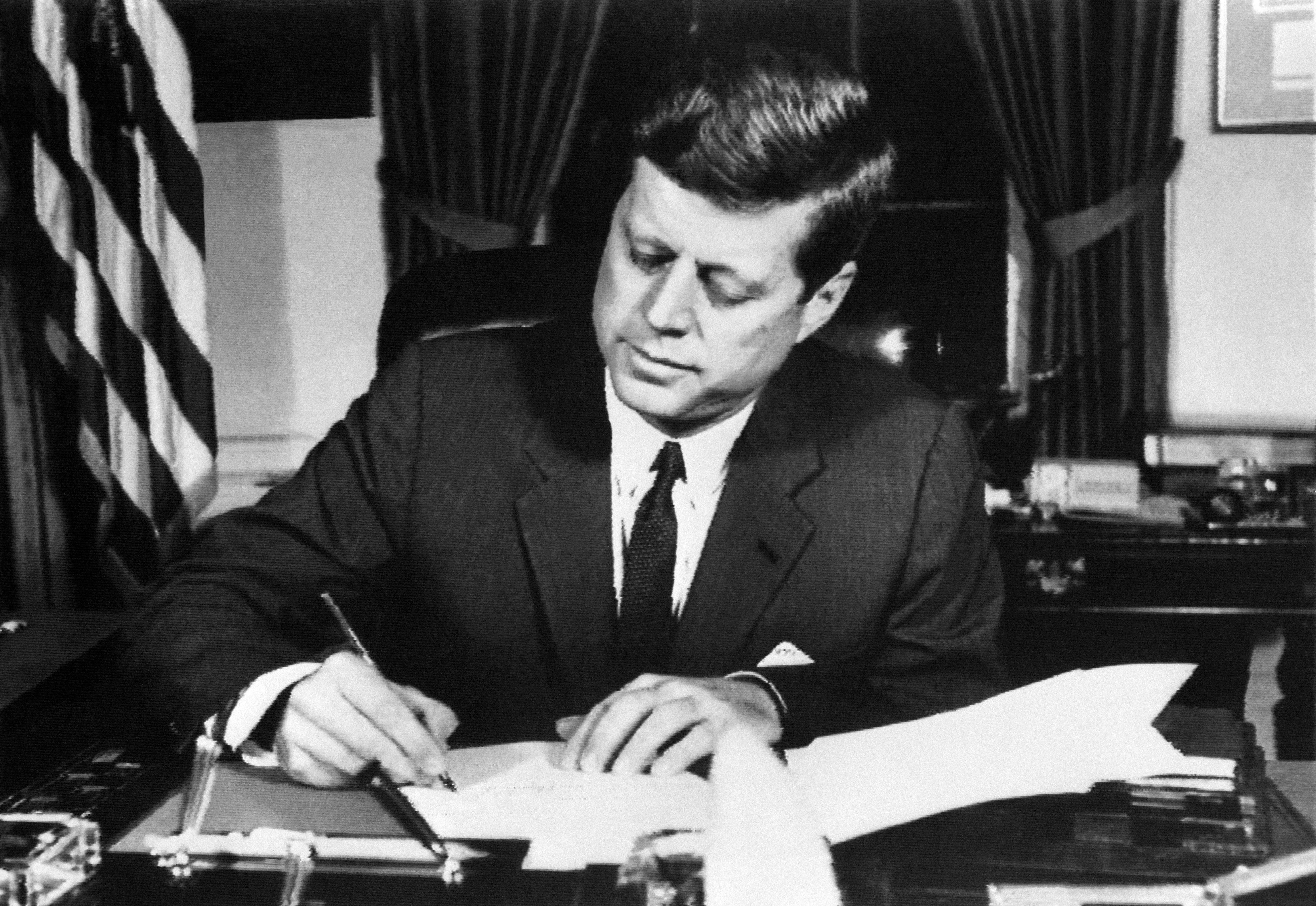 John F Kennedy signs the order of a naval blockade of Cuba