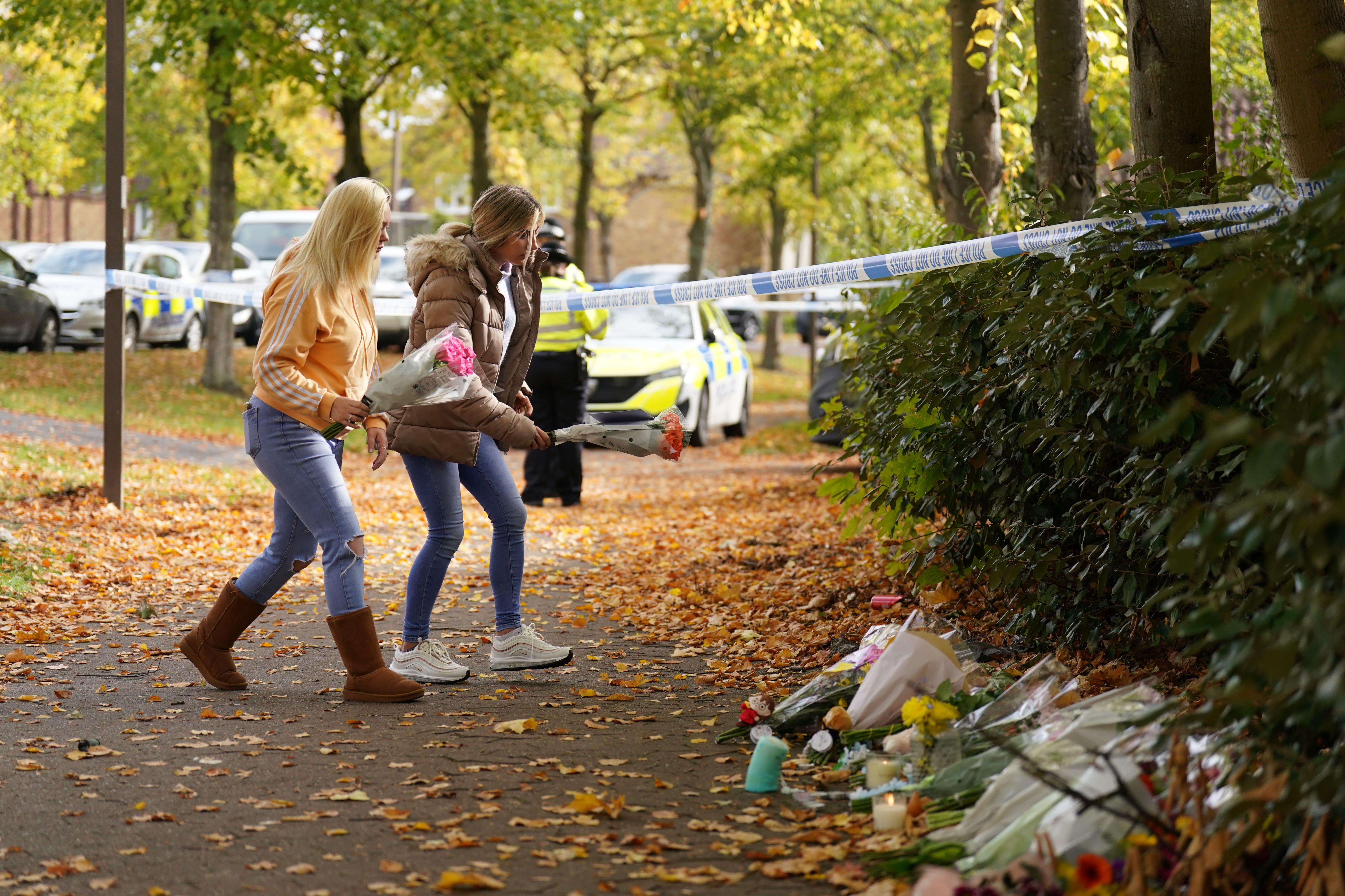 Women place flowers at the scene in Loxbeare Drive, Furzton, Milton Keynes (Joe Giddens/PA)