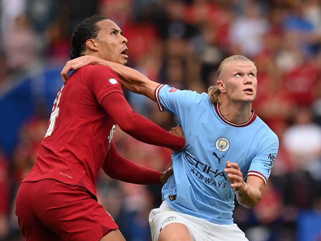 <p>Liverpool defender Virgil van Dijk challenges for the ball with Manchester City striker Erling Haaland</p>
