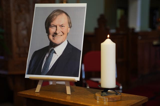 <p>A candle and a photo at a vigil in Leigh-on-Sea, Essex for David Amess </p>