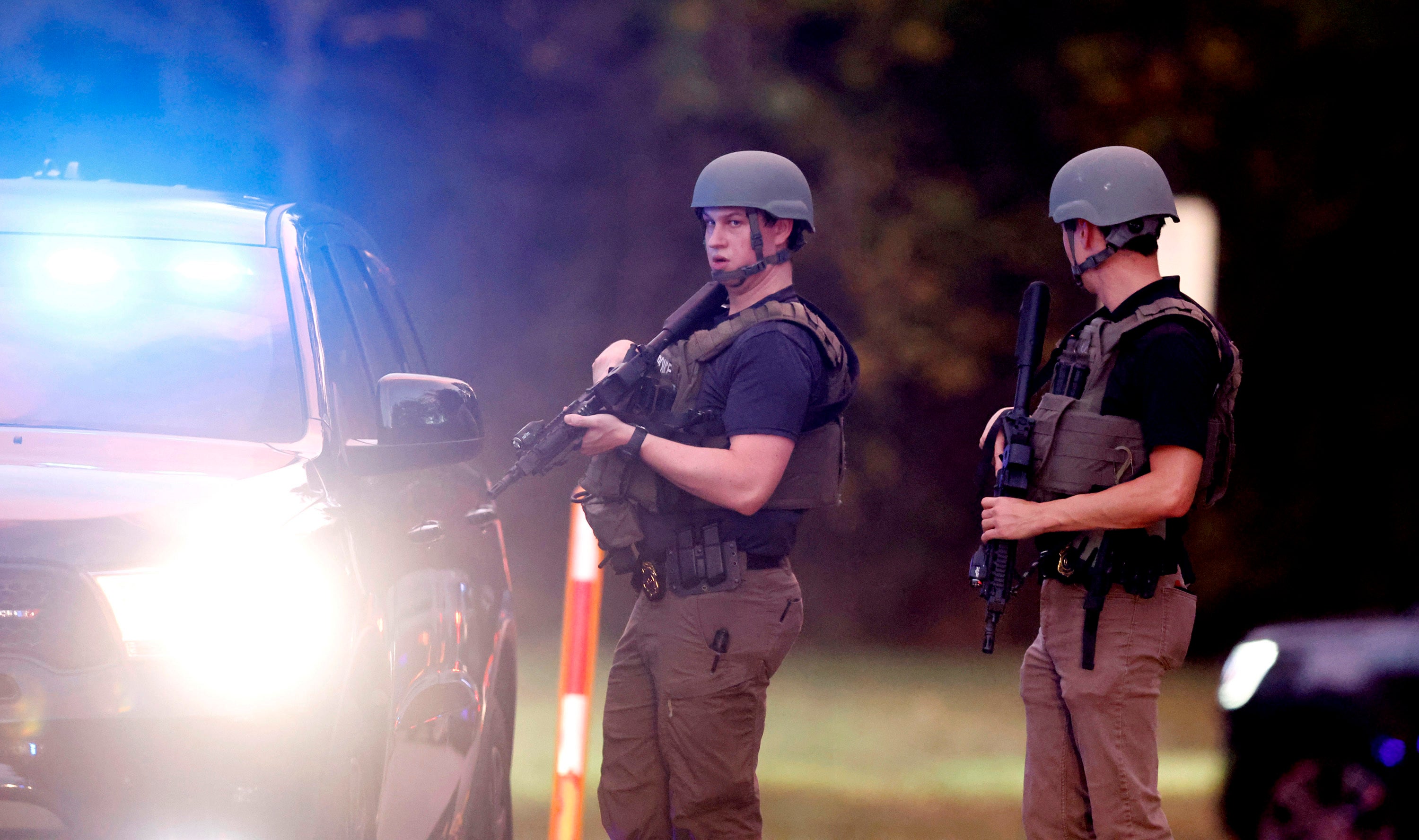 Law enforcement stand at the entrance to Neuse River Greenway Trail parking at Abington Lane following a shooting in Raleigh, N.C., Thursday, Oct. 13, 2022