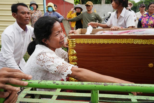 <p>Mother of Son Sophat, a teen victim of a boat accident, cries by her daughter’s coffin during a funeral procession</p>