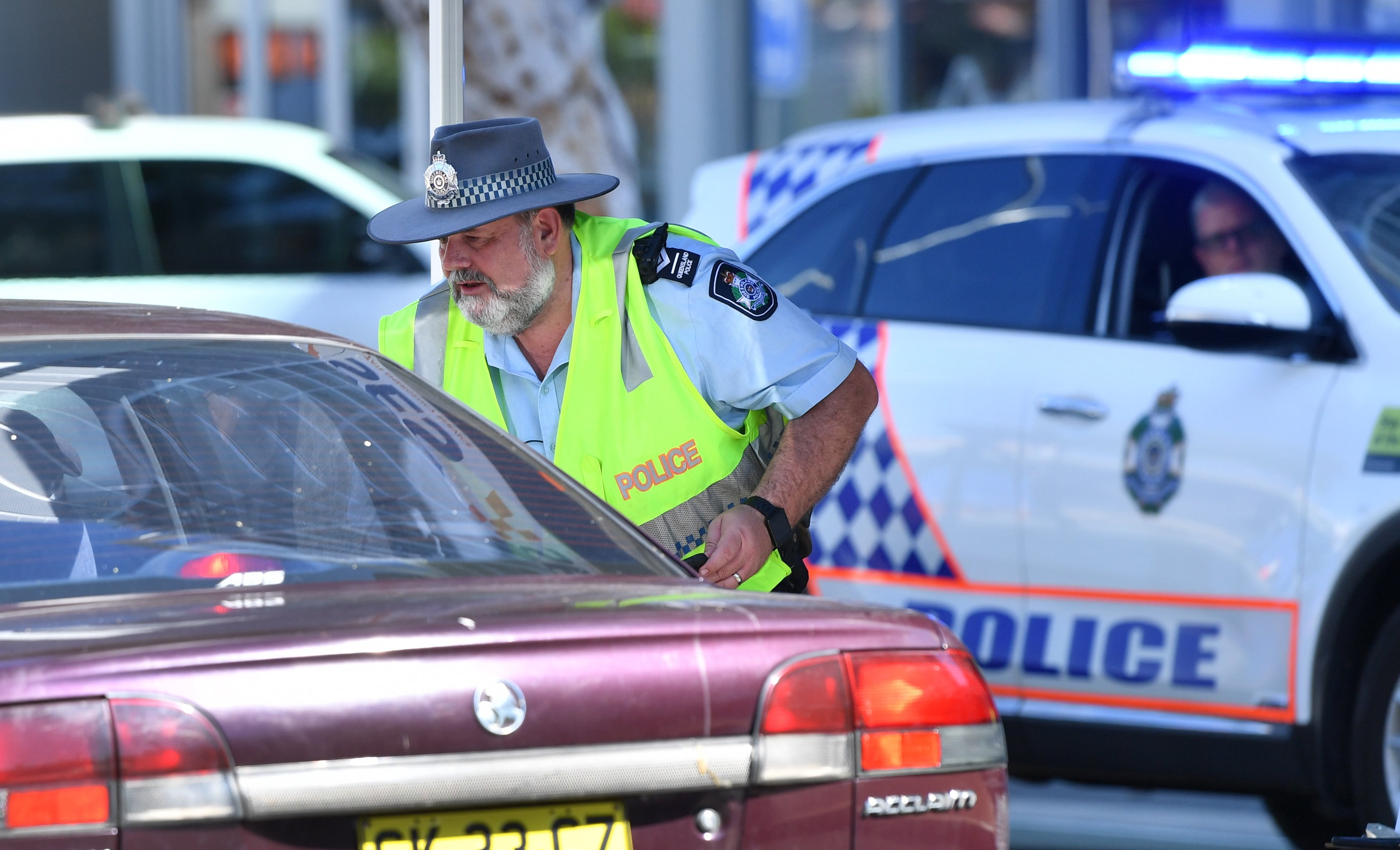 Representational image of a policeman stopping a car at a checkpoint on the Queensland and New South Wales border on Griffith Street in Gold Coast in Australia in 2020