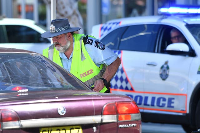 <p>Representational image of a policeman stopping a car at a checkpoint on the Queensland and New South Wales border on Griffith Street in Gold Coast in Australia in 2020</p>