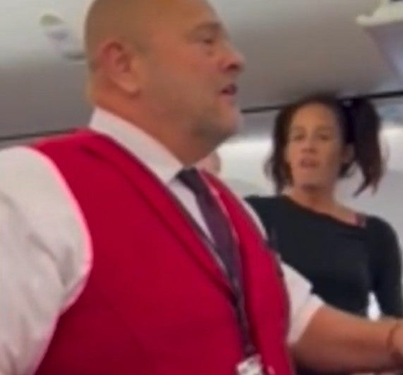 An airline staffer attempts to calm the situation