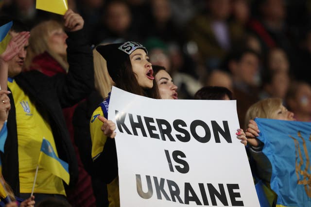 <p>A Dynamo Kyiv fan displays a banner reading ‘Kherson is Ukraine’ at a Europa League match in Poland on Thursday </p>