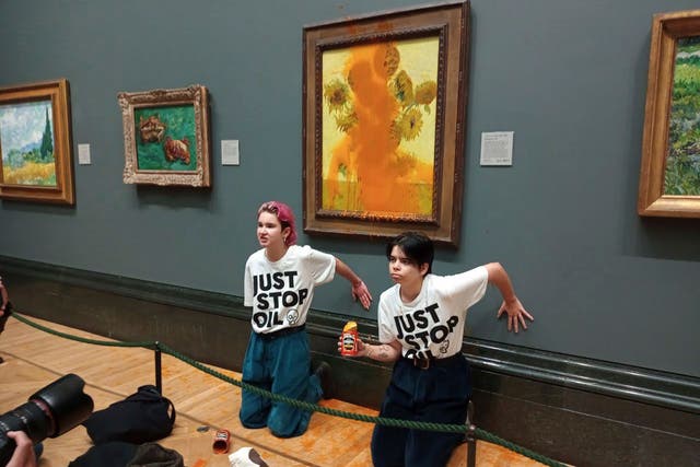 <p>Just Stop Oil protesters glued themselves to the wall after throwing tinned soup at Vincent Van Gogh's famous 1888 work ‘Sunflowers’ at the National Gallery in London on October 14 </p>