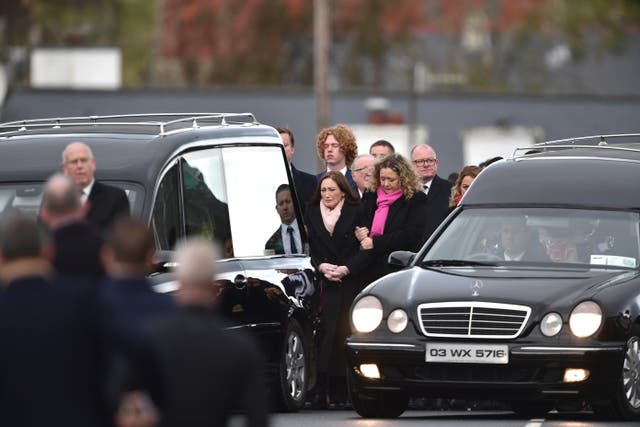 <p>Family members follow the two hearses at the funerals of Robert Garwe, aged 50, and his daughter Shauna Flanagan Garwe, aged five </p>