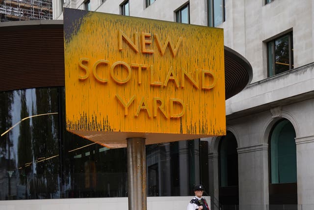 A police officer stood next to the New Scotland Yard sign in London (PA)