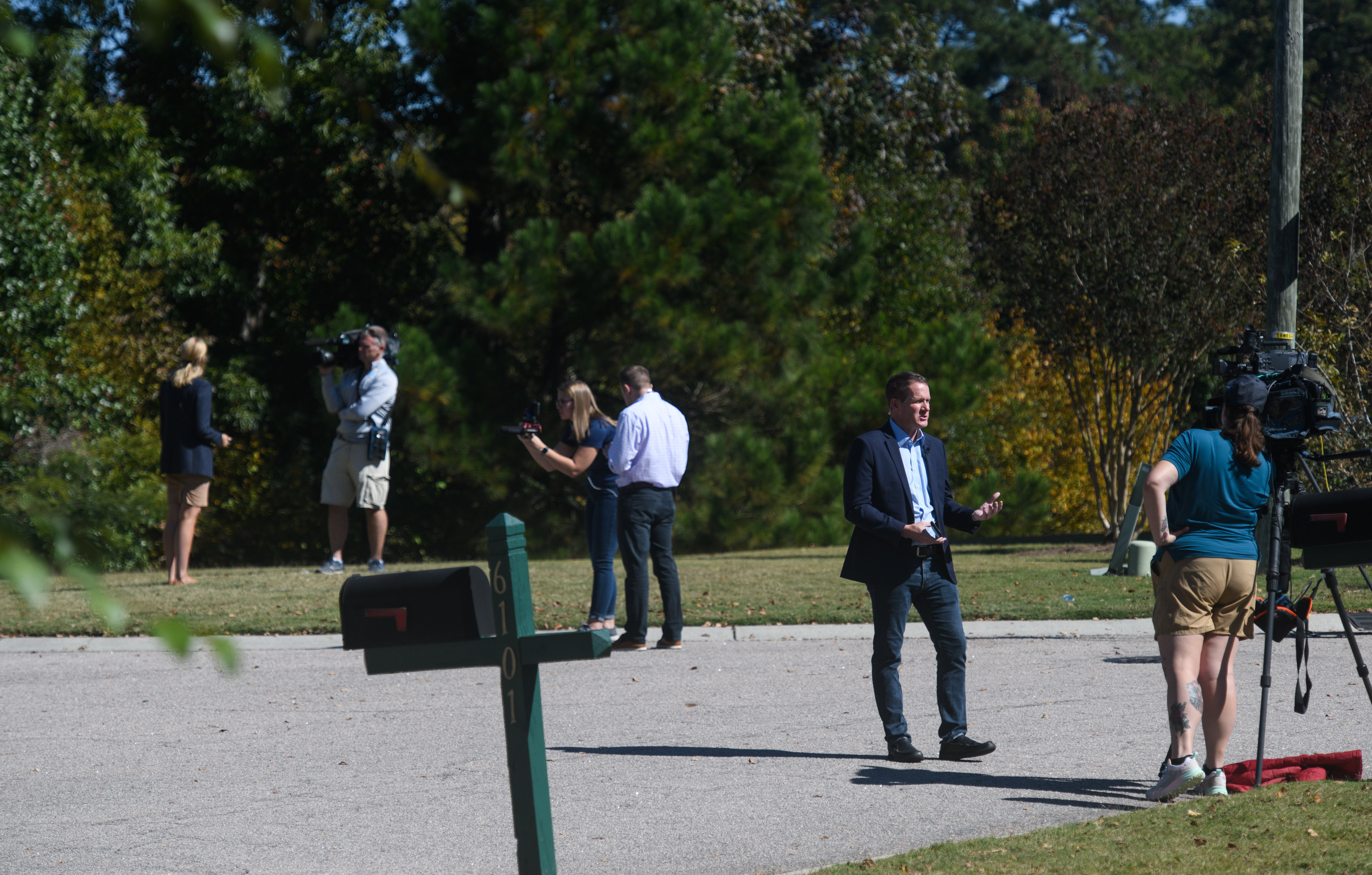 Members of the media work on Osprey Cover Drive where a shooting began on October 14, 2022 in Raleigh, North Carolina