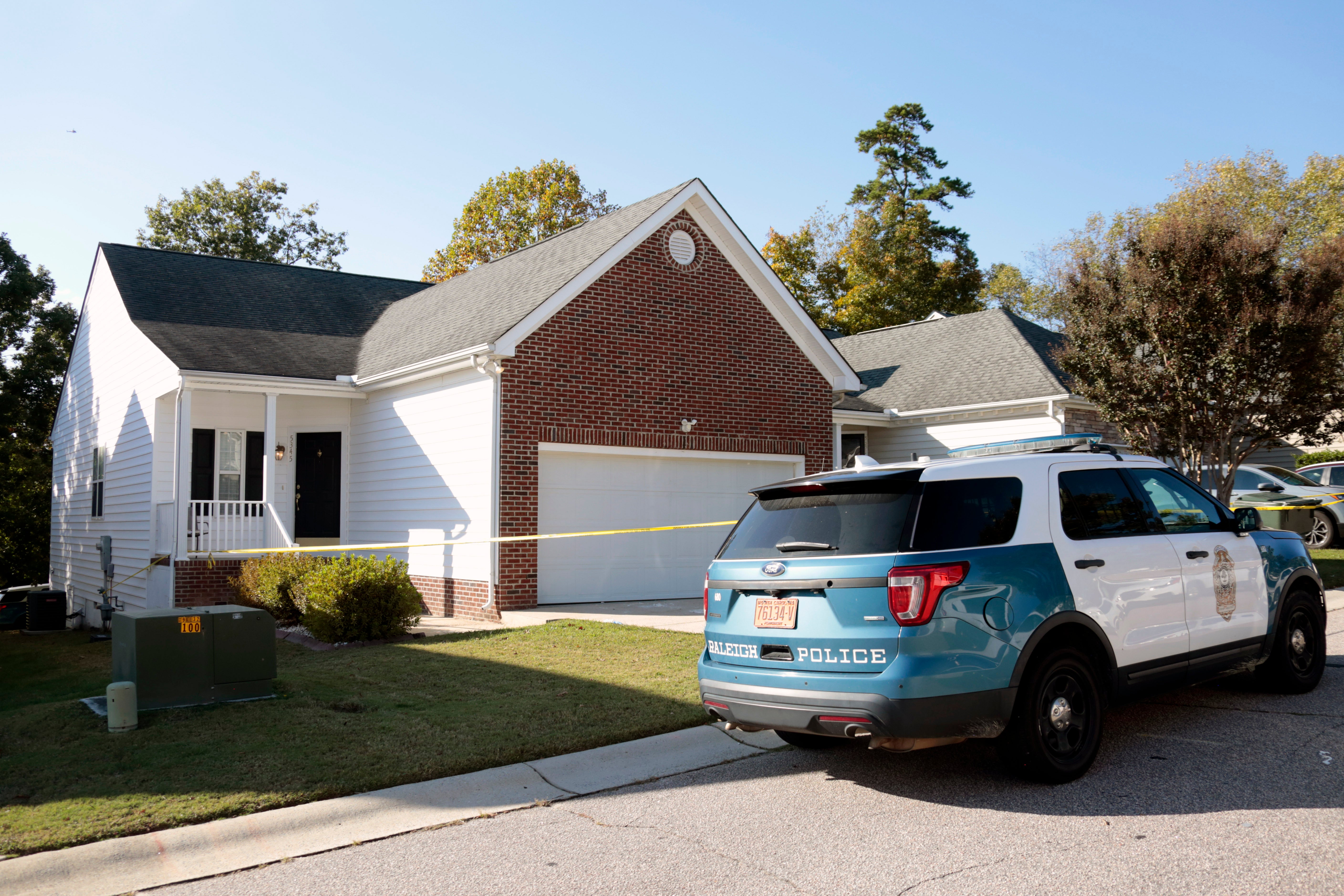 A police officer remains in front of the house where the suspected shooter lived on Sahalee Way following a shooting in Raleigh, N.C., Friday, Oct. 14, 2022