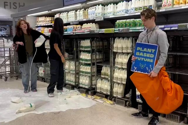 Handout photo issued by Animal Rebellion of supporters of Animal Rebellion pouring out milk in a Waitrose in Edinburgh (Animal Rebellion/PA)