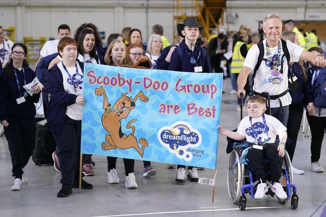 Children leave a hangar event at Heathrow Airport as part of the Dreamflight charity trip (Andrew Matthews/PA)