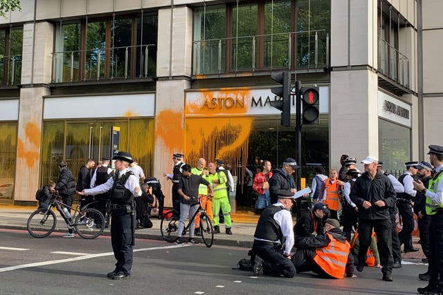 Members of campaign group Just Stop Oil sprayed paint over an Aston Martin showroom and blocked Park Lane in central London in their latest action on Sunday morning (Naomi Clarke/PA)