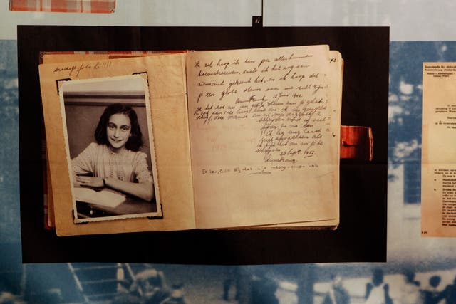 <p>A photo of Anne Frank and her diary </p>