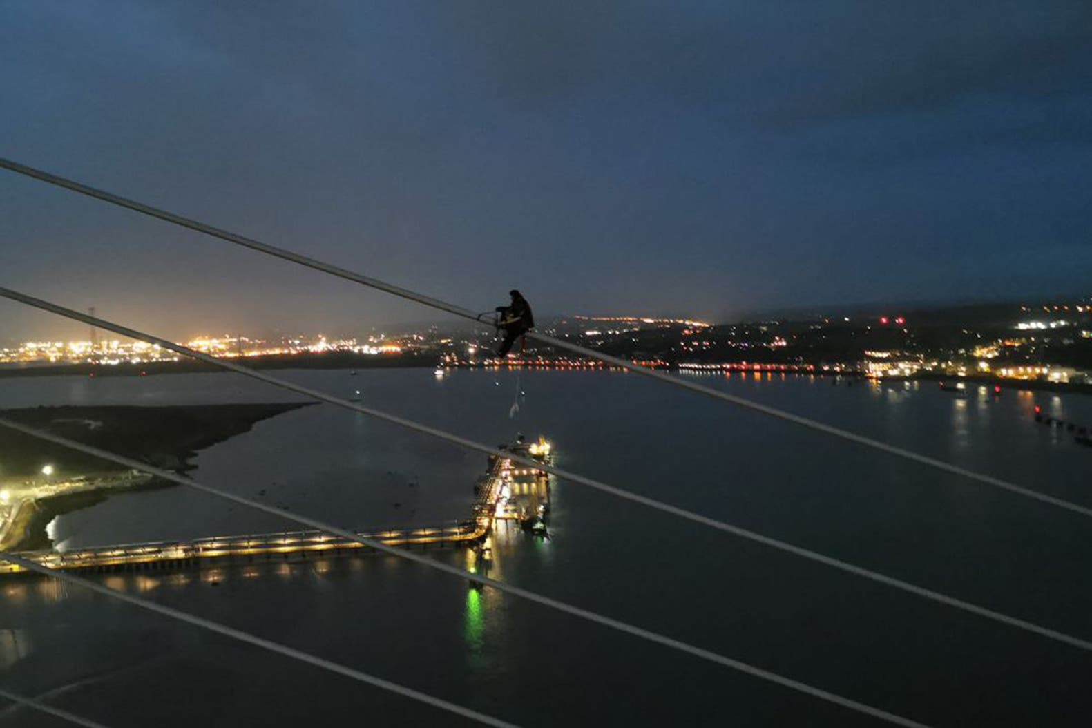 A Just Stop Oil activist scaling the Queen Elizabeth II Bridge at the Dartford Crossing