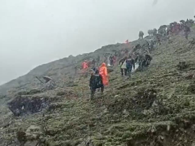 <p>Police and disaster relief officials at the site of the helicopter crash in the Himalayan state of Uttarakhand in India. The crash killed seven people including the pilot</p>