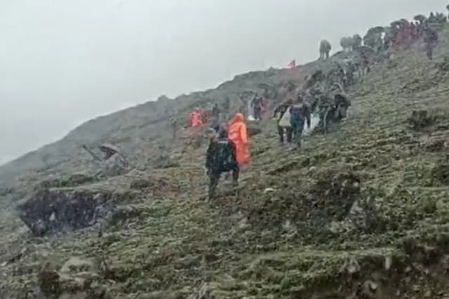 <p>Police and disaster relief officials at the site of the helicopter crash in the Himalayan state of Uttarakhand in India. The crash killed seven people including the pilot</p>