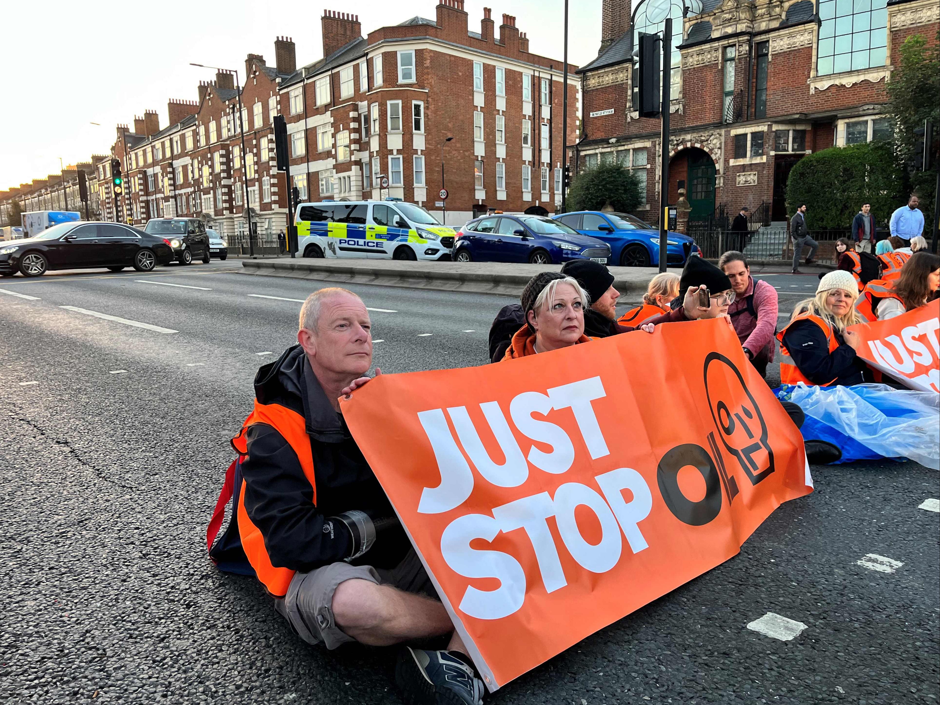 Activists of Just Stop Oil climate campaign group hold a banner at Barons Court in west London as they block the A4