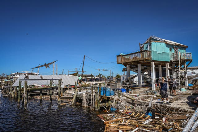 <p>People clean up debris in Fort Myers Beach last month after Hurricane Ian. Officials have reported an uptick of infections with Vibrio vulnificus after the storm, commonly known as a ‘flesh-eating’ bacteria</p>