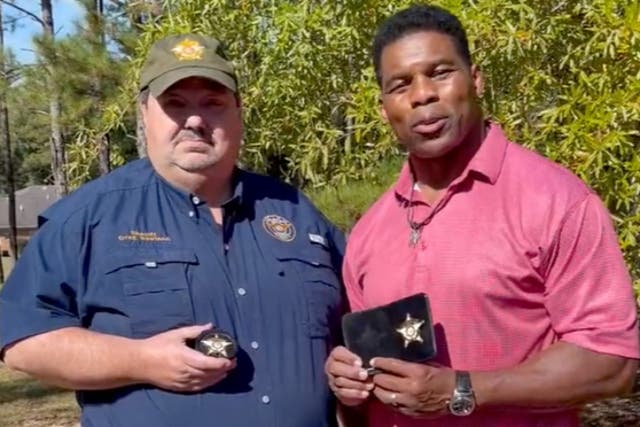 <p>Jefferson County Sheriff Greg Rowland and Republican Senate candidate Herschel Walker hold badges in a video posted to Mr Walker’s Twitter page</p>