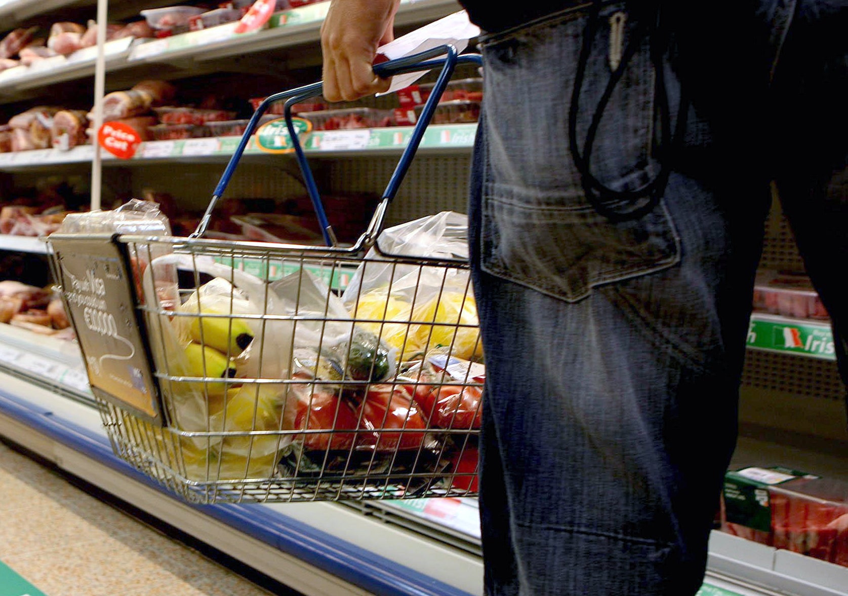 A shopper holding their basket in a supermarket, as food inflation hits its highest rate on record