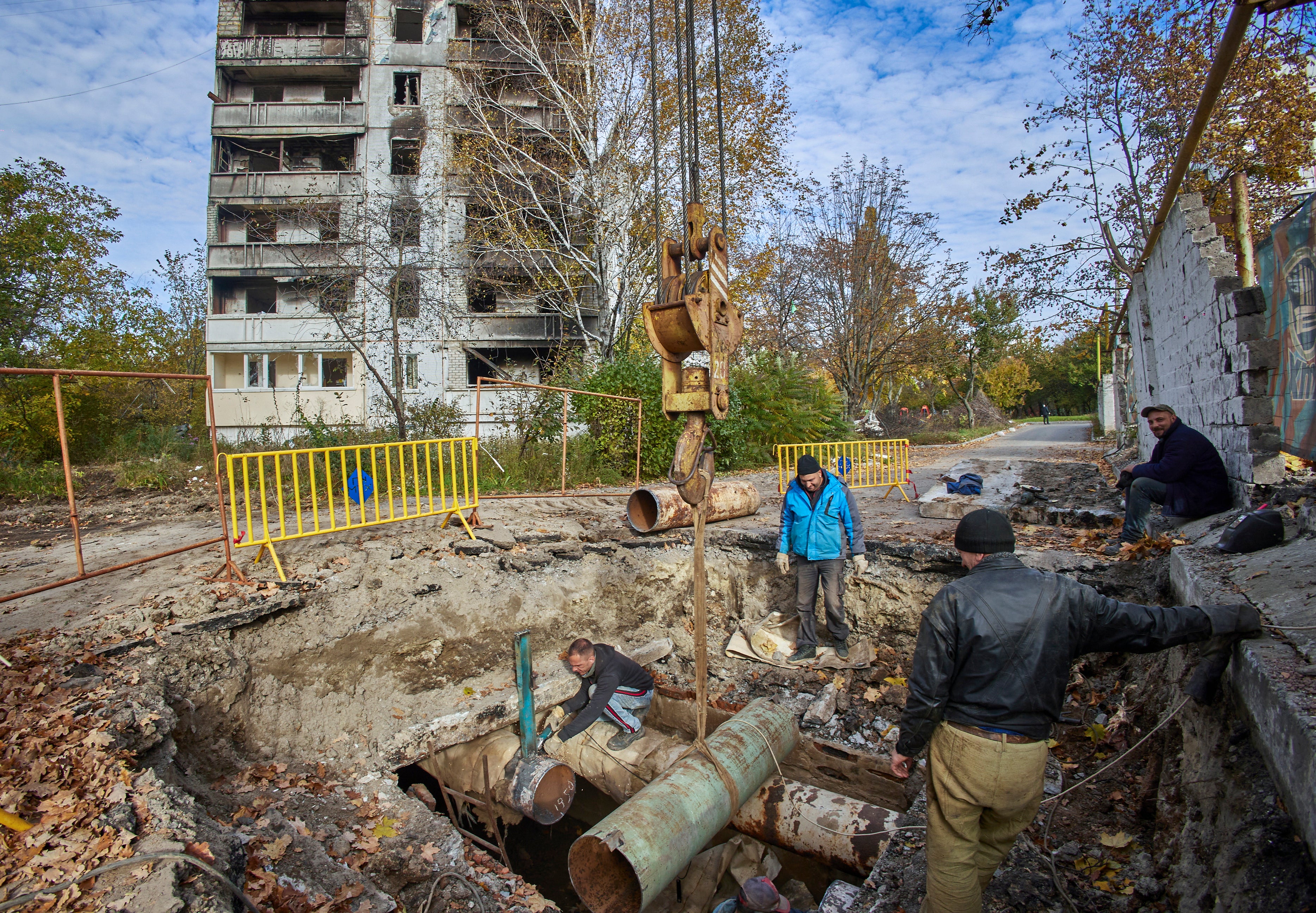 Ukrainian workers repair damaged heating communications of damaged residential buildings in Kharviv