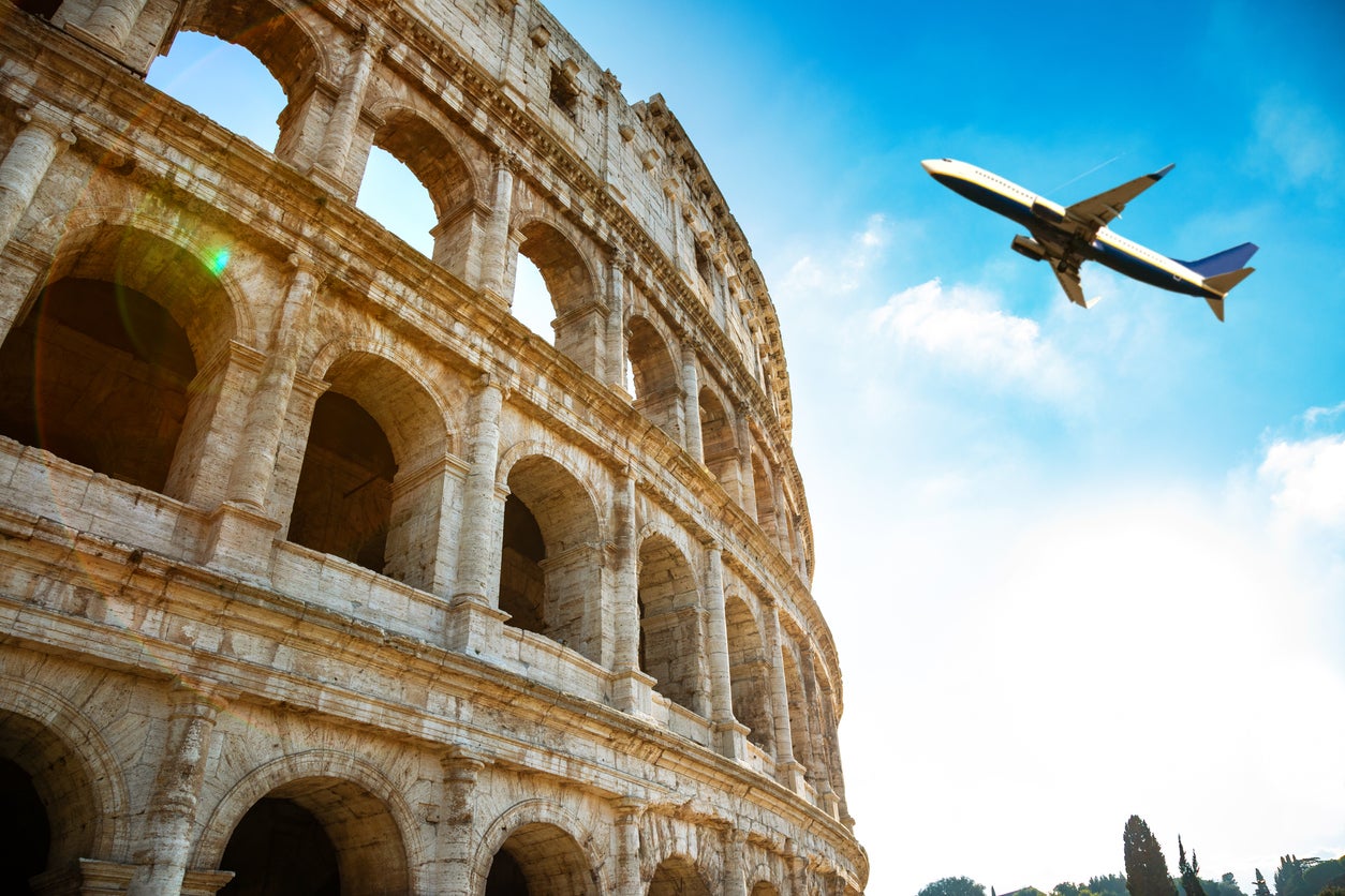 A plane flies over the Colosseum in Rome