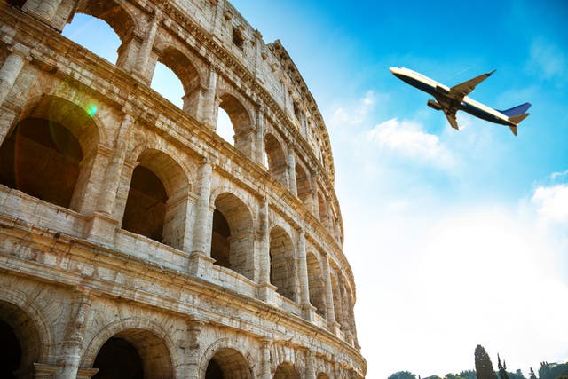 <p>A plane flies over the Colosseum in Rome</p>