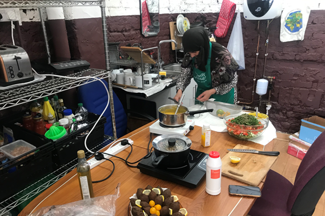 <p>Jomana, a Syrian mother of four, prepares meals for visitors to Dad’s House, a community food bank and support centre in West Brompton </p>