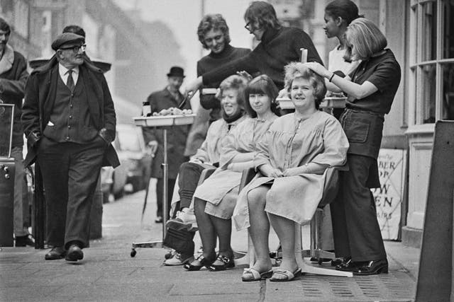 <p>Customers having their hair cut on the pavement in Hatton Garden, London, due to power cuts in 1972</p>