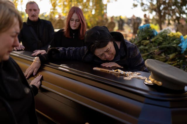 <p>Tatiana Alexeyevna mourns over the coffin of her son Colonel Oleksiy Telizhenko during his funeral in Bucha</p>