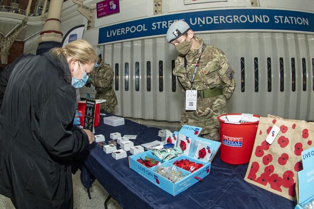Members of 7 Battalion REME, 132 Aviation Support Squadron selling poppies at Liverpool Street underground station, London (Sergeant Todd/MoD/PA)