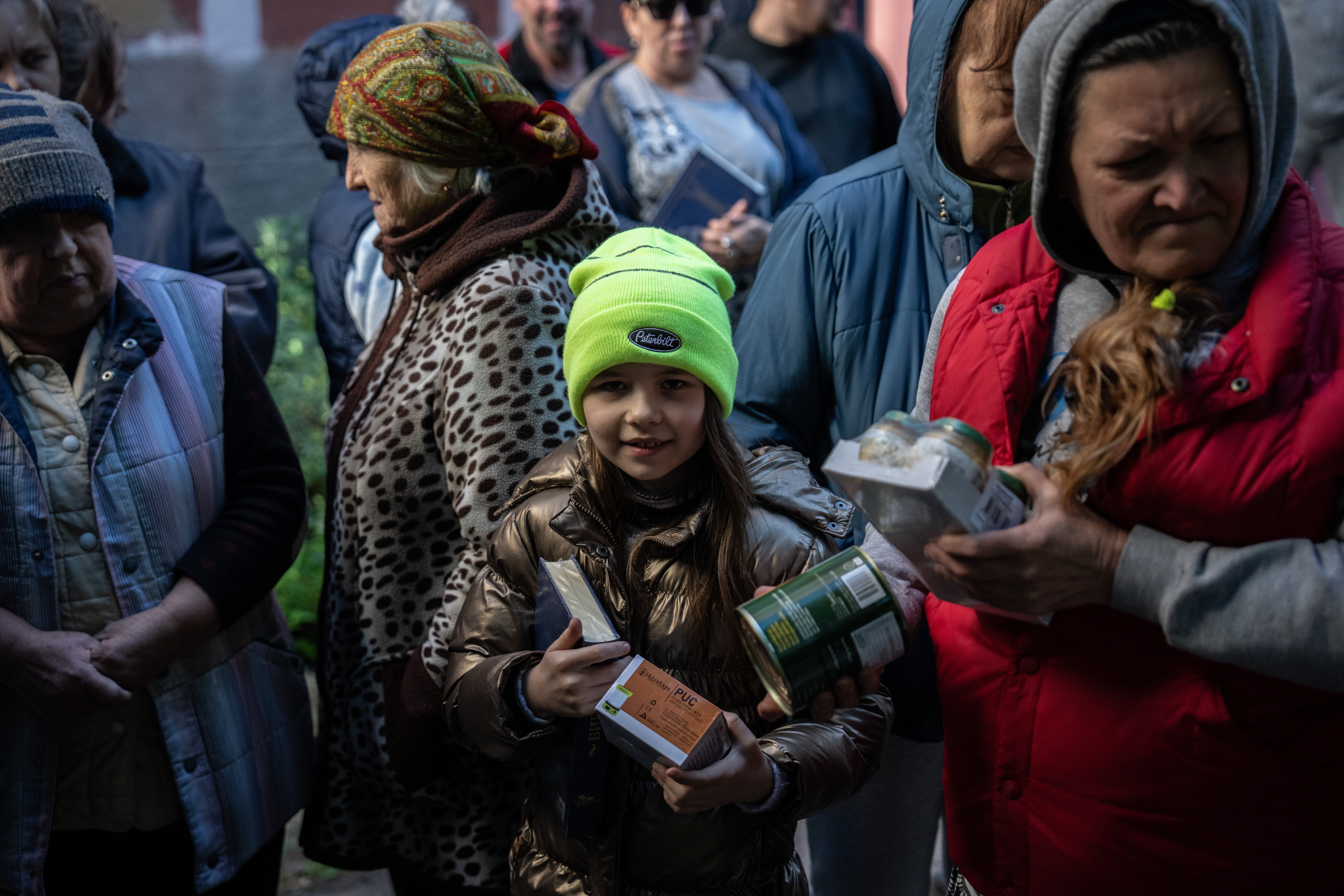 A young girl is among residents getting food aid in Bakhmut – a risky process with Russian drones overhead and shells bombarding the city