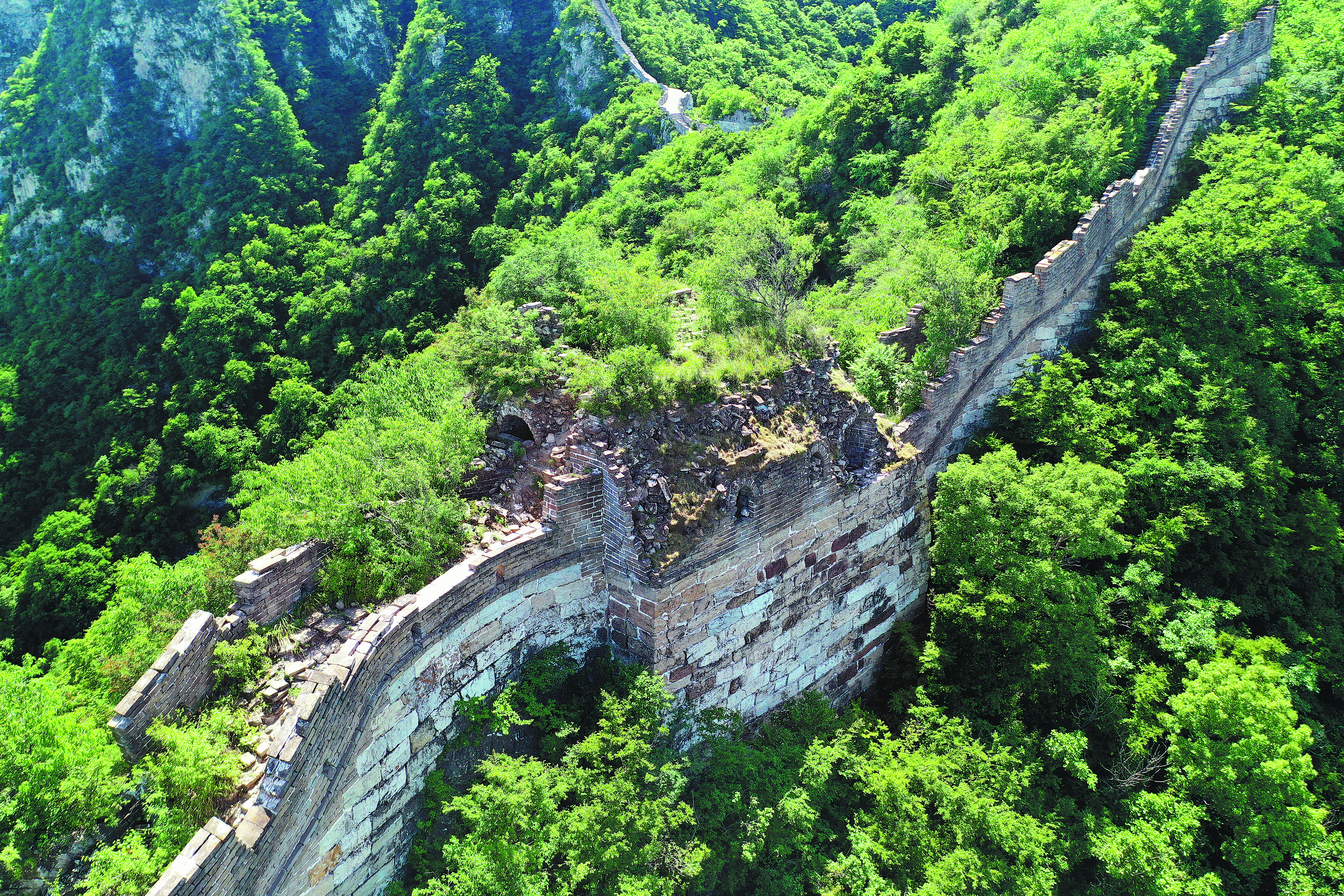 The Jiankou section of the Great Wall ribbons over the top of jagged green mountains in Huairou district, northern Beijing