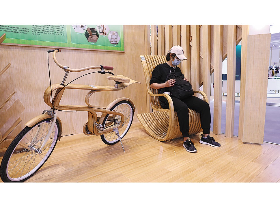 A visitor tries out a rocking chair made of bamboo at Inbar’s booth during the China International Fair for Trade in Services