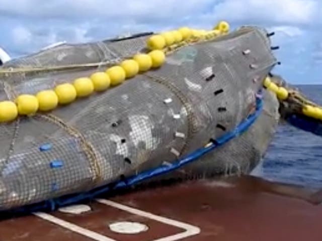 <p>A net drop 10 tonnes of trash from the ocean onto the deck of a ship</p>
