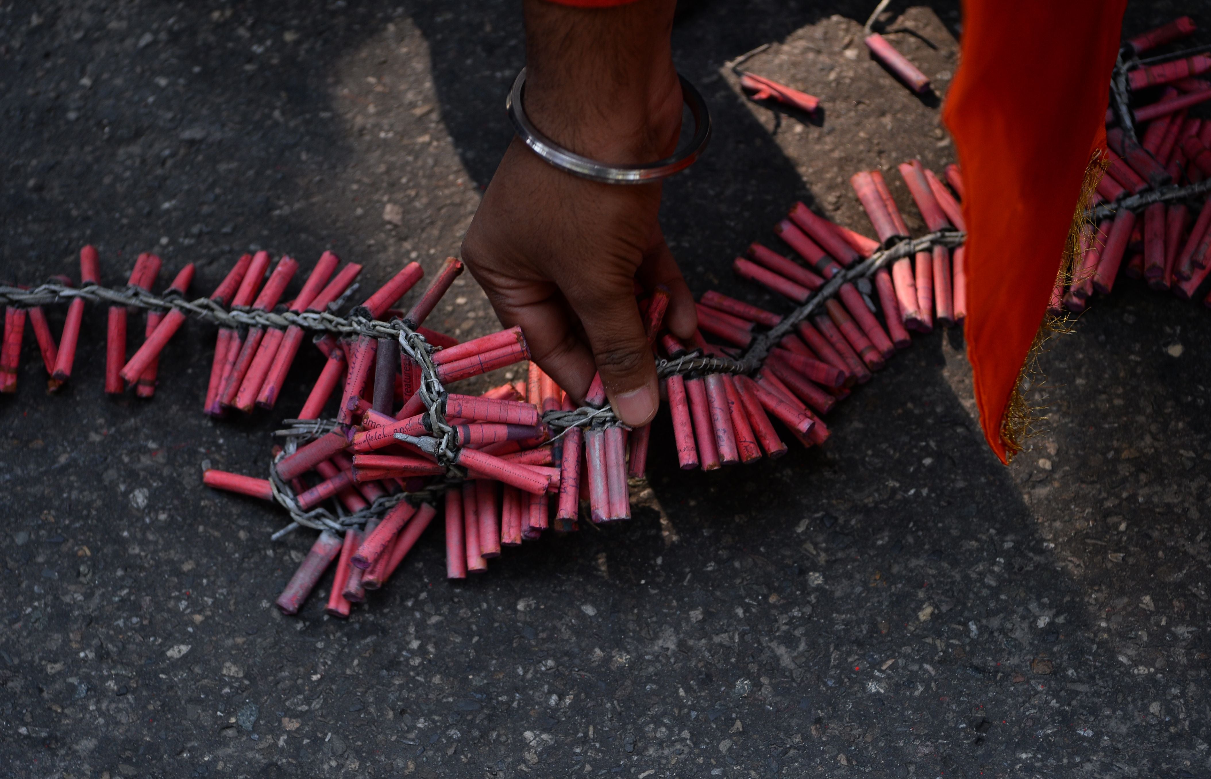 File: A person seeing arranging garlands of firecrackers made up small bombs in New Delhi