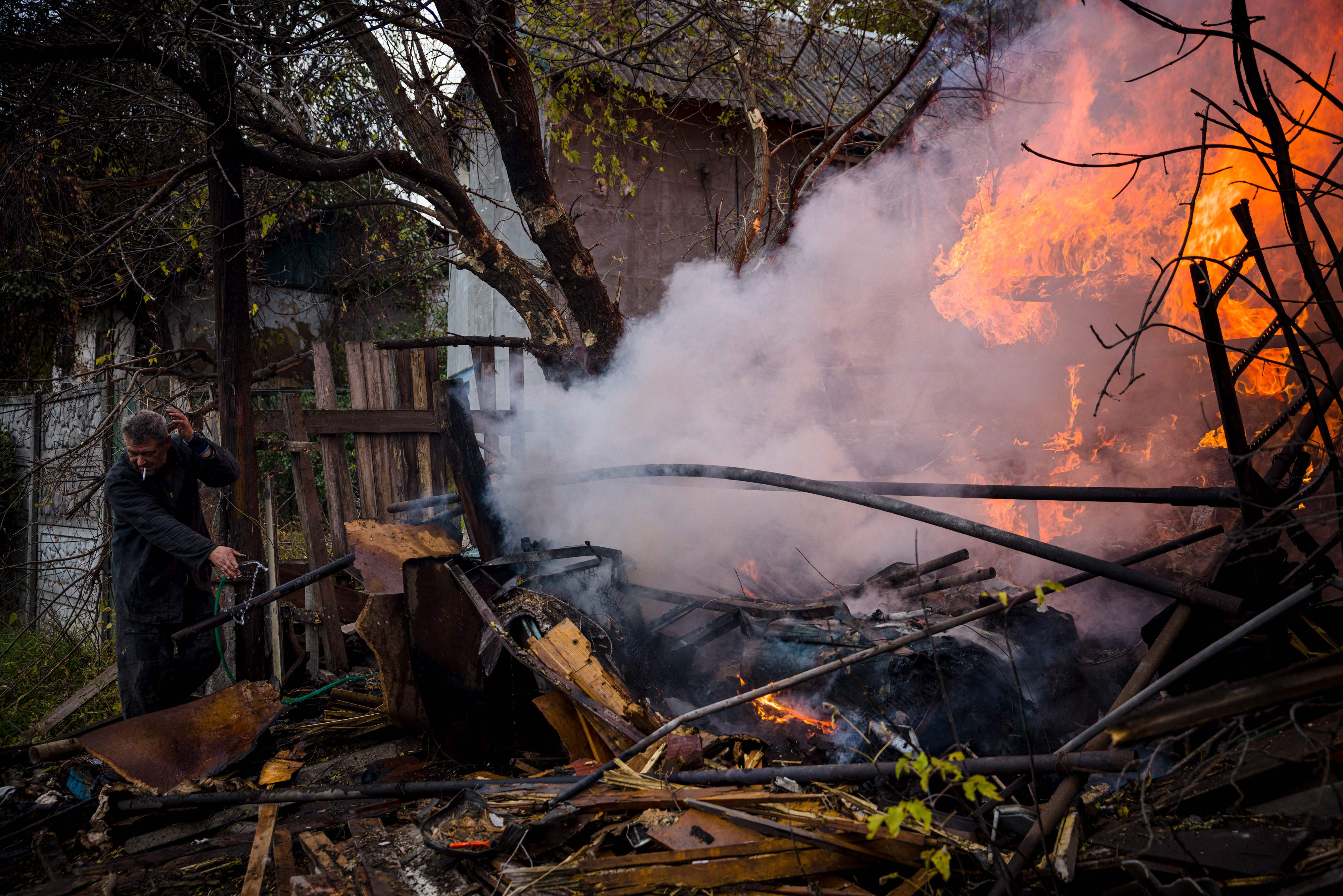 A local resident works to extinguish a fire after shelling in the Donbas town of Bakhmut on Sunday