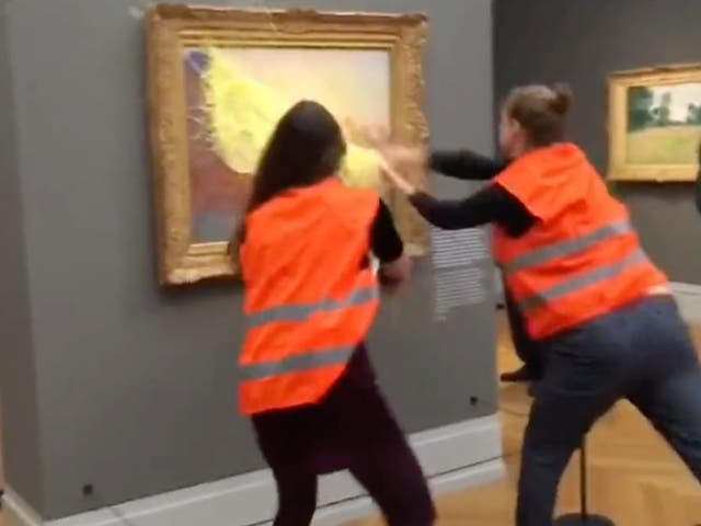 <p>Two protestors throw mashed potato at Claude Monet’s ‘Les Meules' (Haystacks) at the Museum Barberini in Potsdam</p>