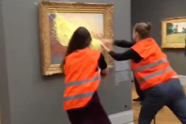 <p>Two protestors throw mashed potato at Claude Monet’s ‘Les Meules' (Haystacks) at the Museum Barberini in Potsdam</p>