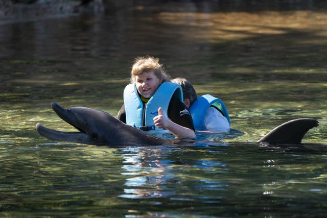 Jessica Ewing, 14, from Saltcoats in North Ayrshire, swims with a dolphin during the Dreamflight visit to Discovery Cove in Orlando, Florida (Kirsty O’Connor/PA)