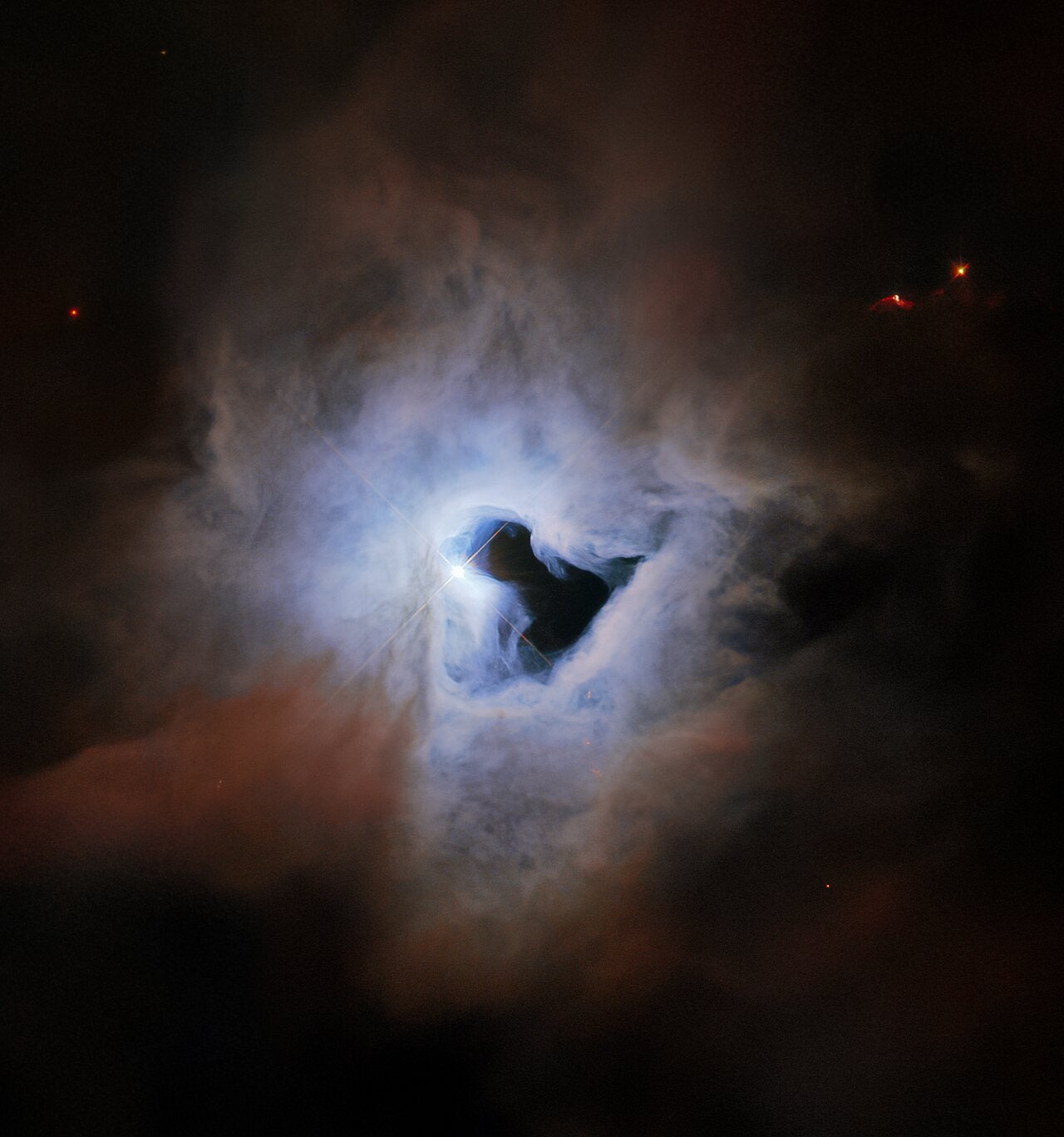 The reflection nebular NGC 1999 lies about 1,350 light years from Earth in the constellation Orion, and exhibits an inky black central “keyhole” in this image taken by the Hubble Space Telescope