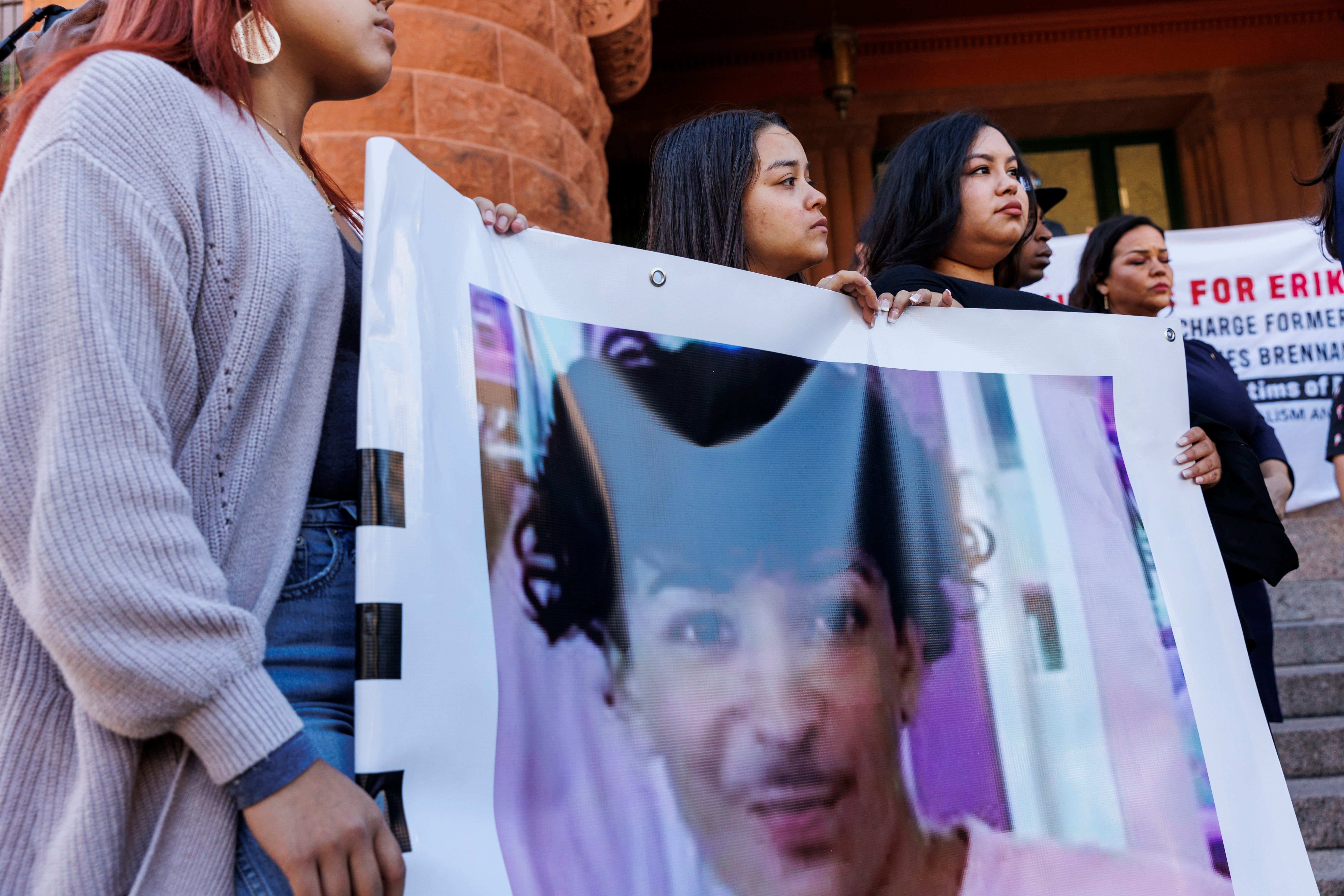 Daleen Garcia, front left, and two of Erik Cantu's siblings hold a banner featuring a picture of him during a press conference held to update the public about his current medical condition in front of the Bexar County Courthouse in San Antonio, Tuesday, Oct. 25, 2022
