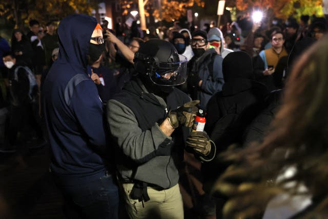 <p>An unidentified person wields a can of bear mace before using it on protesters ahead of a scheduled event featuring far right group Proud Boys' founder Gavin McInnes at Pennsylvania State University in State College, Pennsylvania, U.S., October 24, 2022</p>
