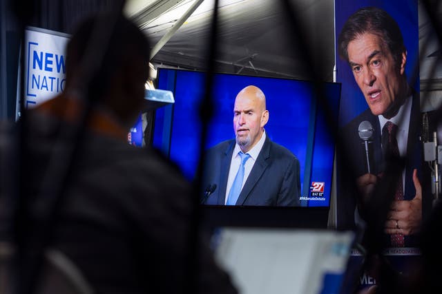 <p>Members of the media watch Democratic Senate candidate for Pennsylvania John Fetterman face off against Republican candidate Mehmet Oz on a TV monitor during the candidates' only debate in Harrisburg, Pennsylvania, USA, 25 October 2022</p>