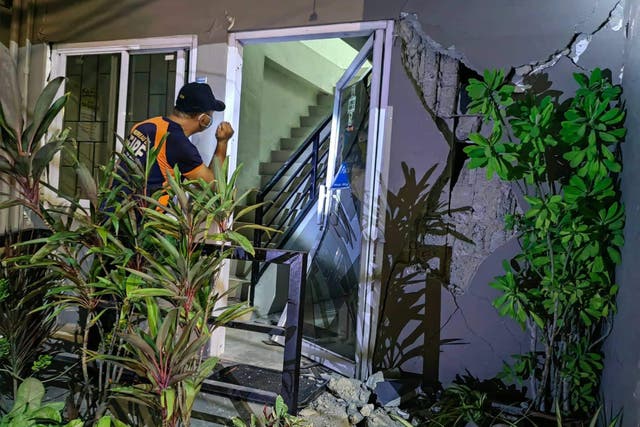 <p> An officer conducts inspection of a damaged building in Batac city, Ilocos Norte</p>