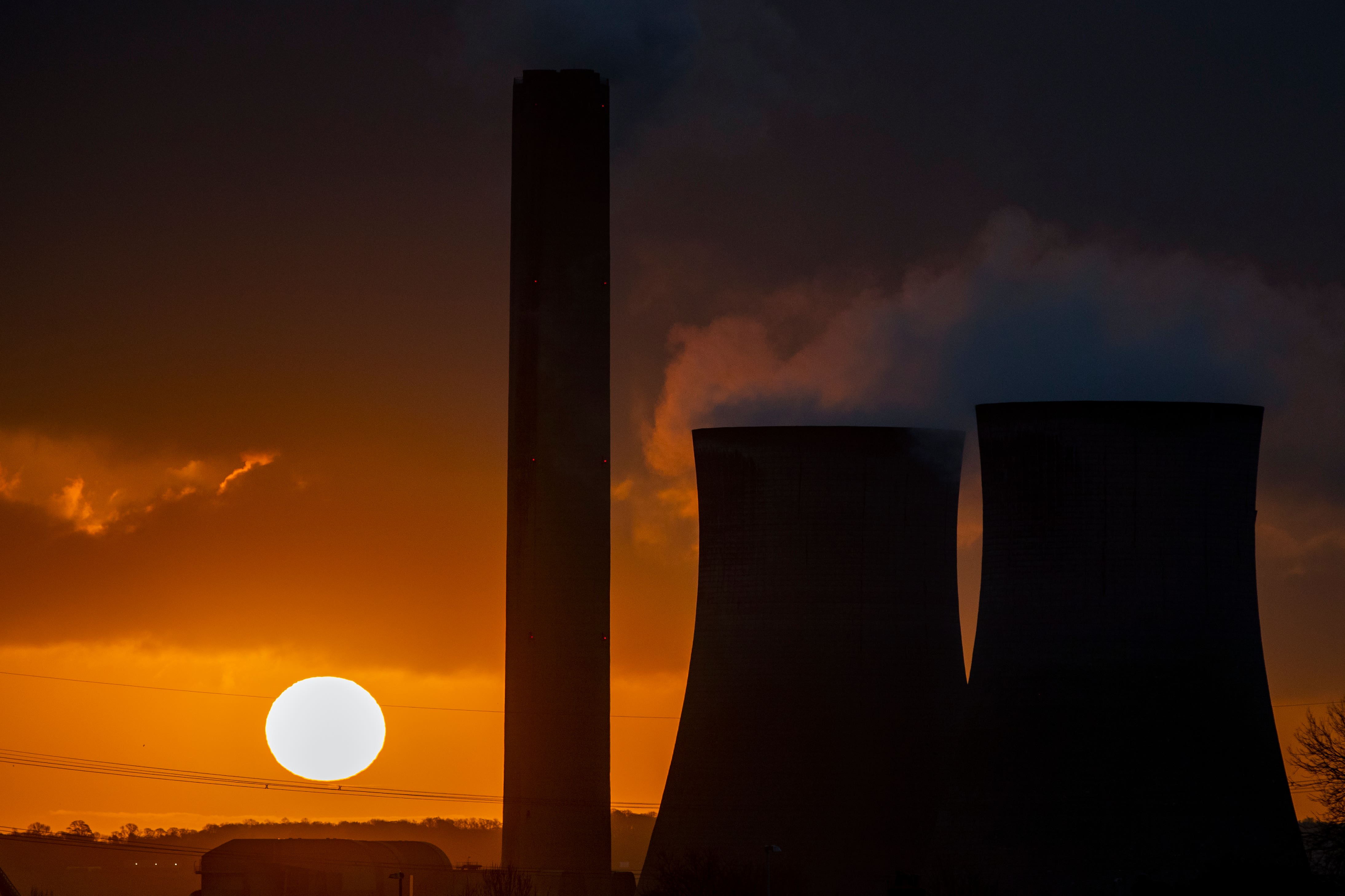 The sun rises behind a power plant (Peter Byrne/PA)